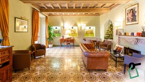 A spacious living area with a patterned floor, a leather sofa, and a dining area with a Christmas tree. - Hotiday Roma Borghese (Rome)