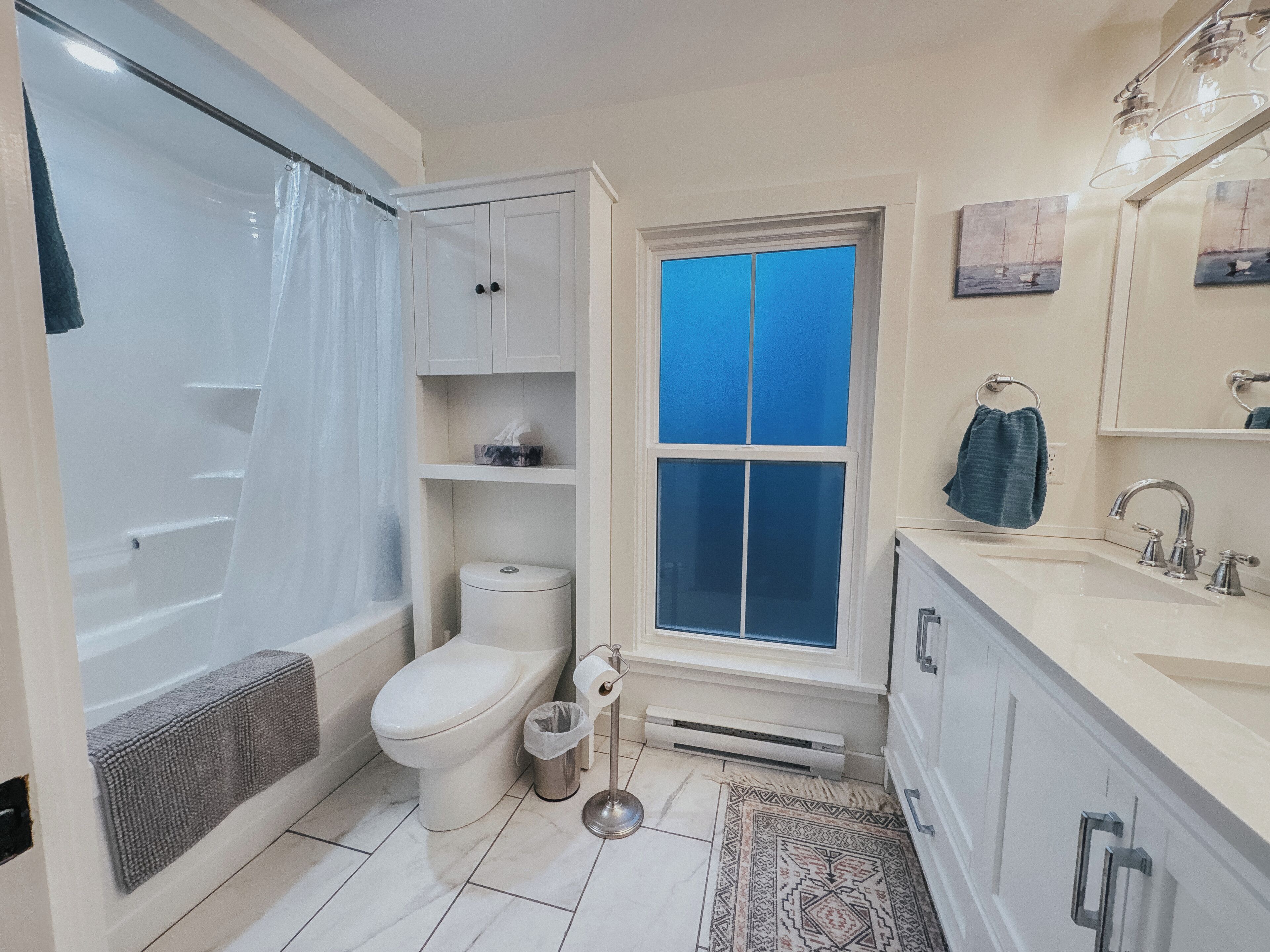 A bathroom with a bathtub, toilet, and sink.