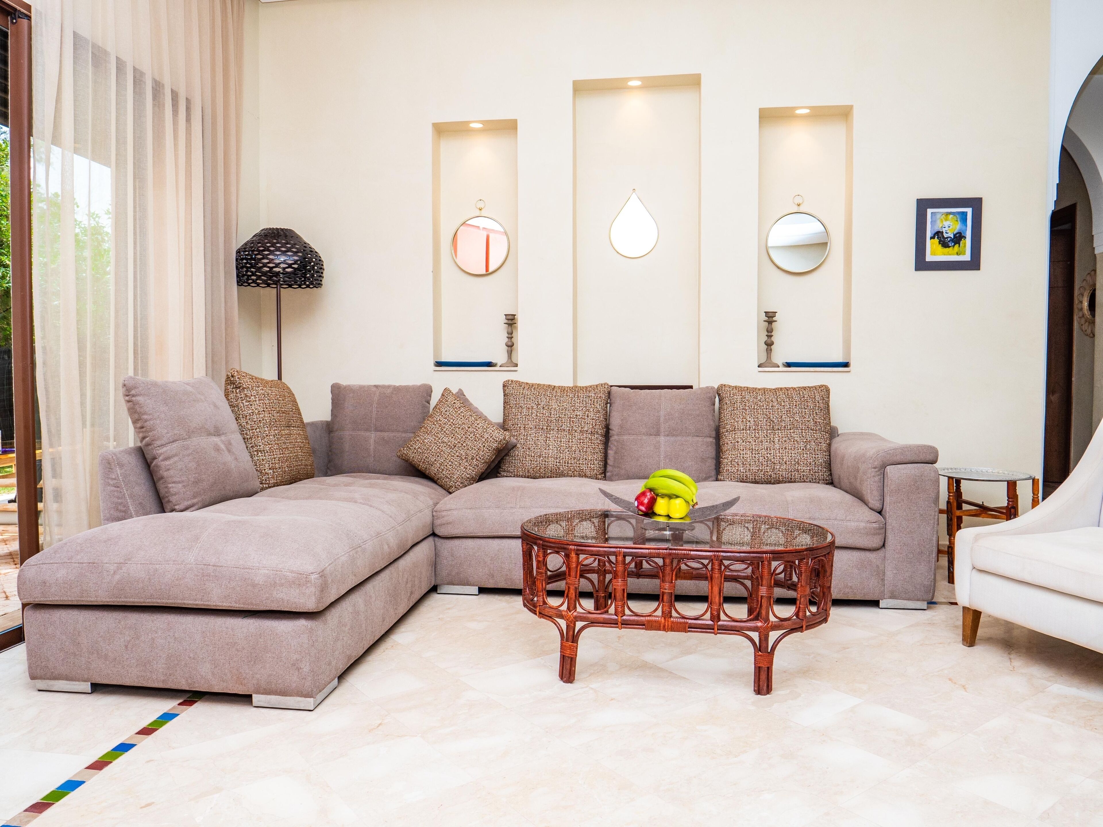 A living room with a sectional sofa, a round coffee table, and a small side table.