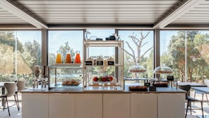A modern cafe with a glass display case filled with pastries and a coffee machine. - Hotiday Toscana Riparbella (Riparbella)