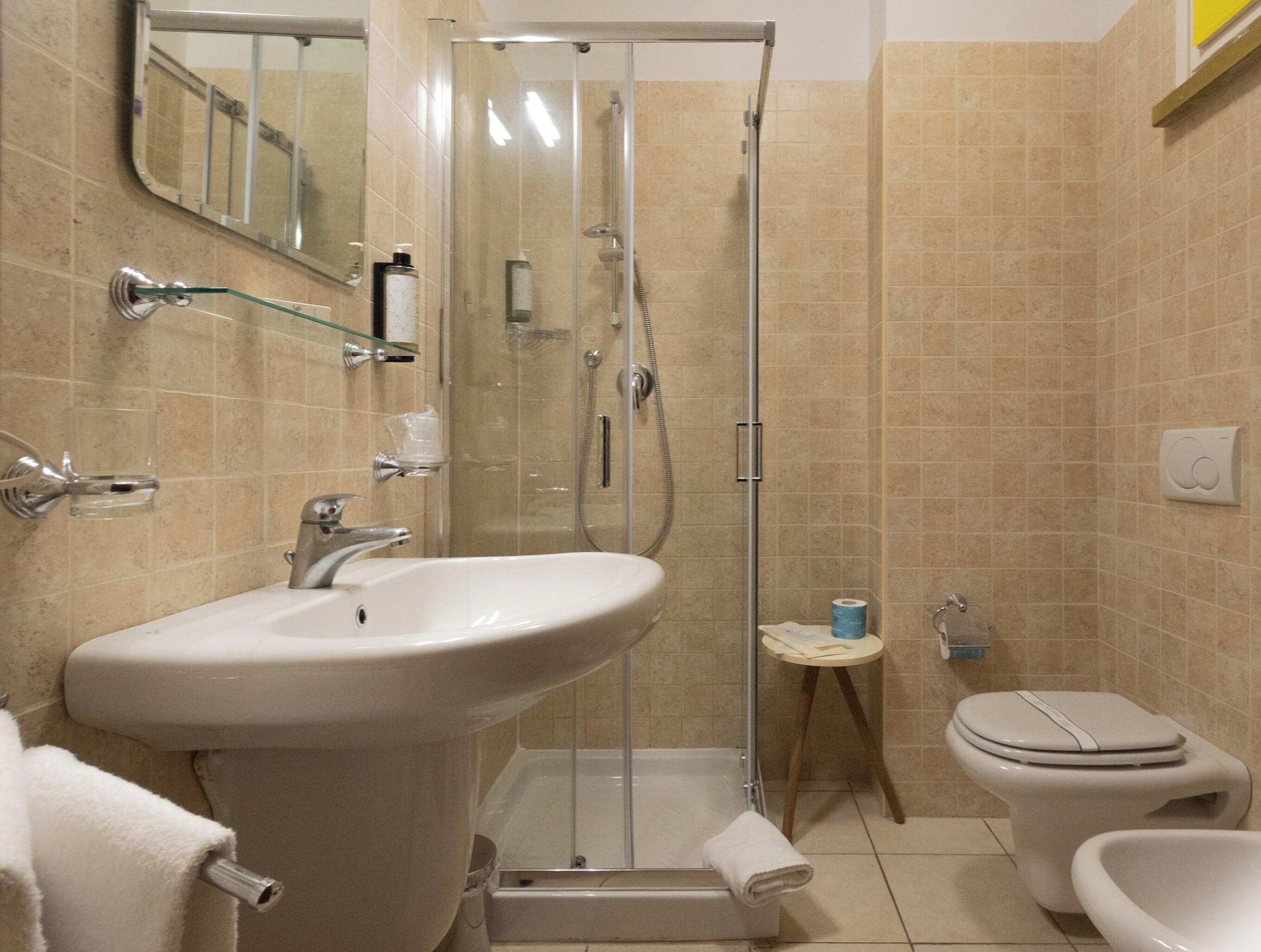 A bathroom with a shower, toilet, and sink.