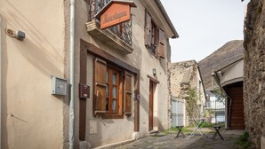 Un edificio con un letrero que dice 'Moustayou', una puerta de madera y una reja de metal.