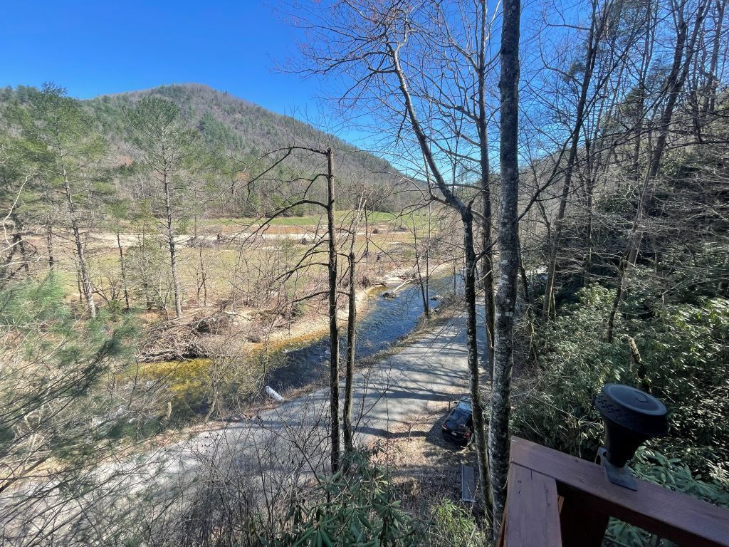 Un paisaje natural con un río, árboles y una terraza de madera.