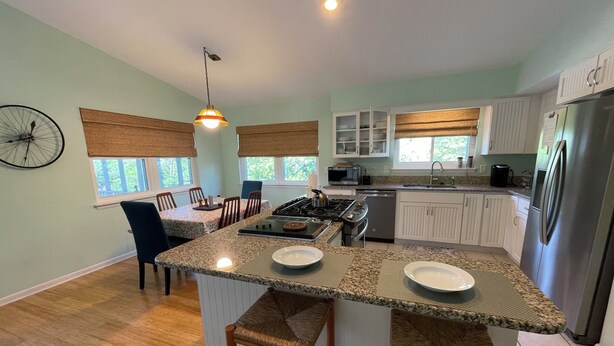 A modern kitchen with granite countertops, white cabinets, and a stainless steel refrigerator. - Spacious 5-bedroom "double house" in amazing Santa Rosa Beach with heated pool (Santa Rosa Beach)