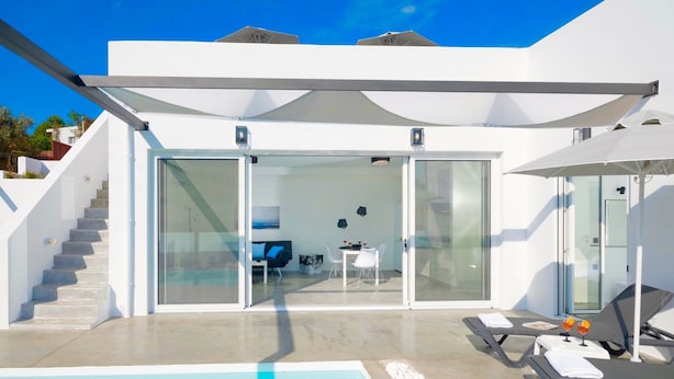 Uma villa moderna com piscina, área de estar coberta ao ar livre e escadaria que leva aos andares superiores.