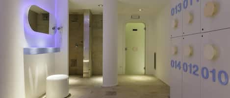 Un pasillo moderno con una pared de pantalla digital, un banco blanco y piso de baldosas.