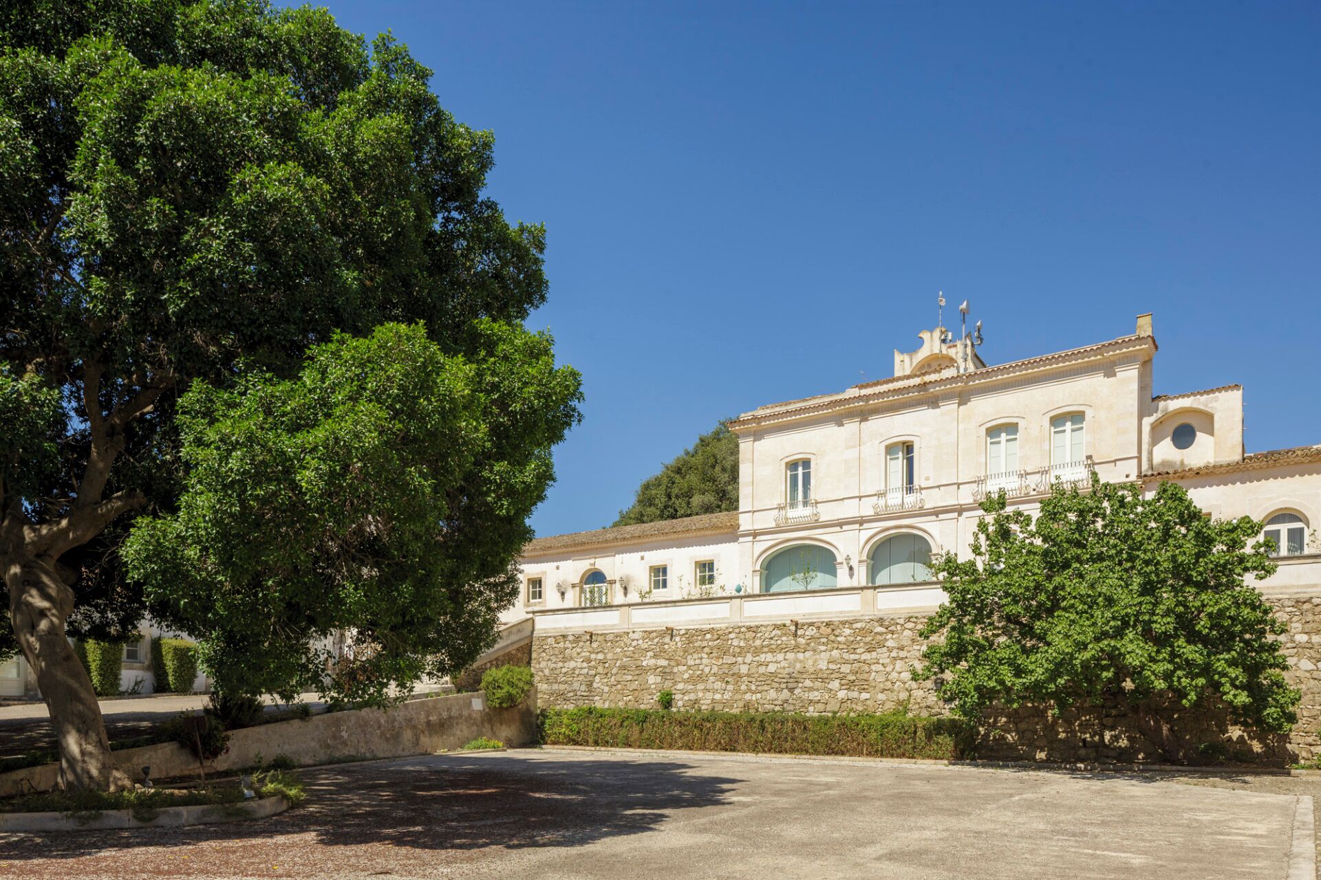 A building with a stone facade, arched windows, and a flat roof.