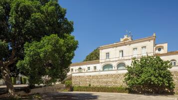 A building with a stone facade, arched windows, and a flat roof.