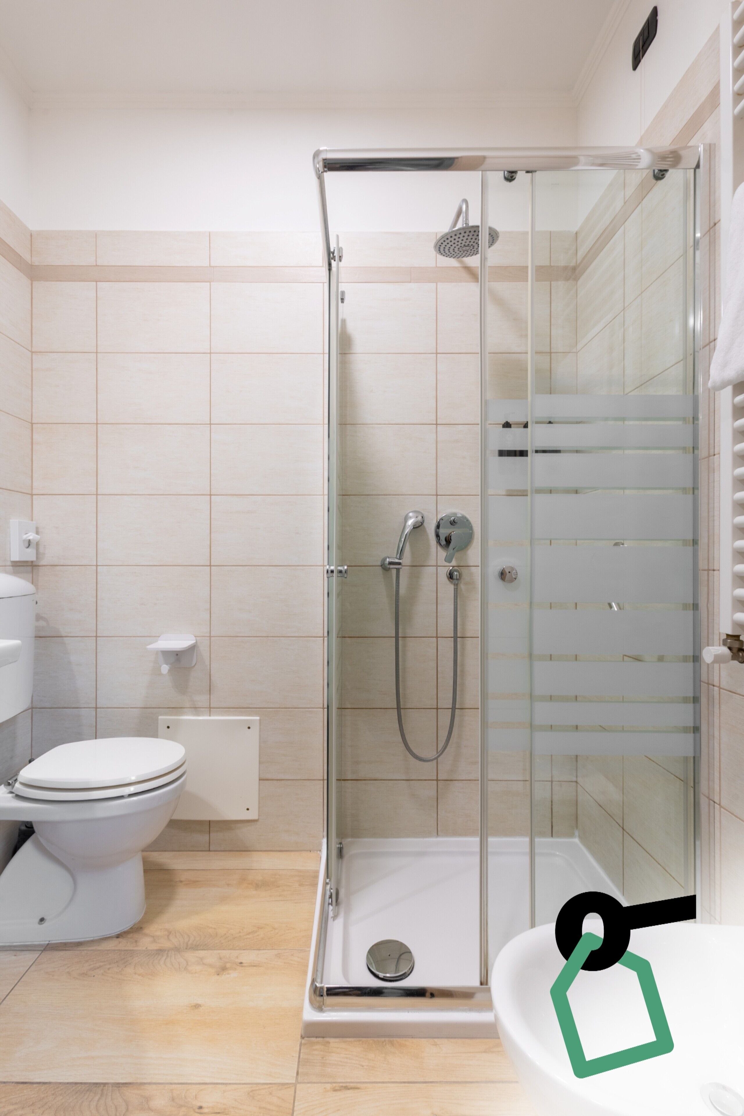 Un baño con ducha envuelta en vidrio, inodoro y lavabo.