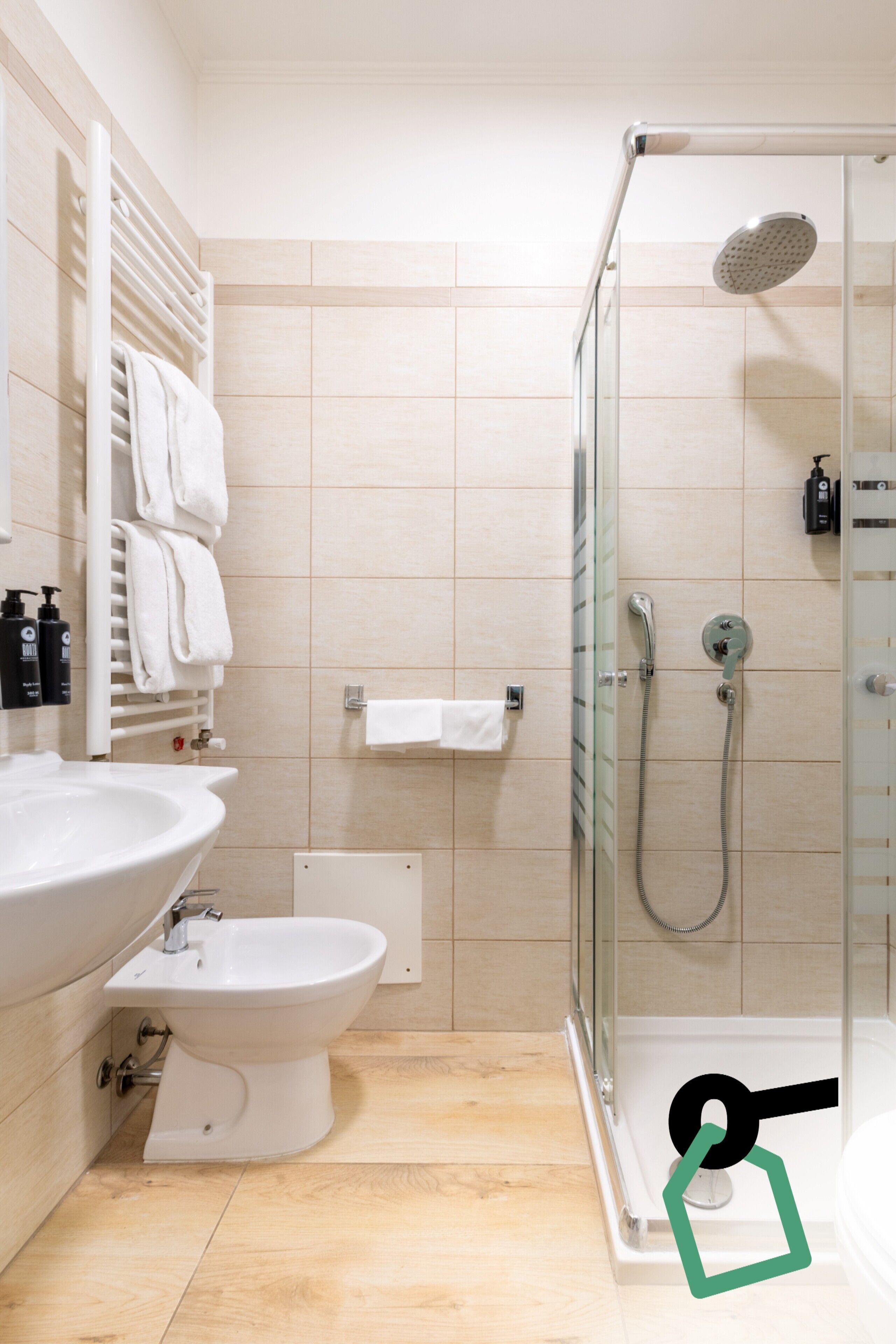 Un baño moderno con ducha de vidrio, un lavamanos blanco y un bidé.