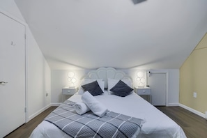 A bedroom with a bed, bedside tables, and a headboard. - The Poconos Fun Chalet w/Game Room (Tobyhanna)