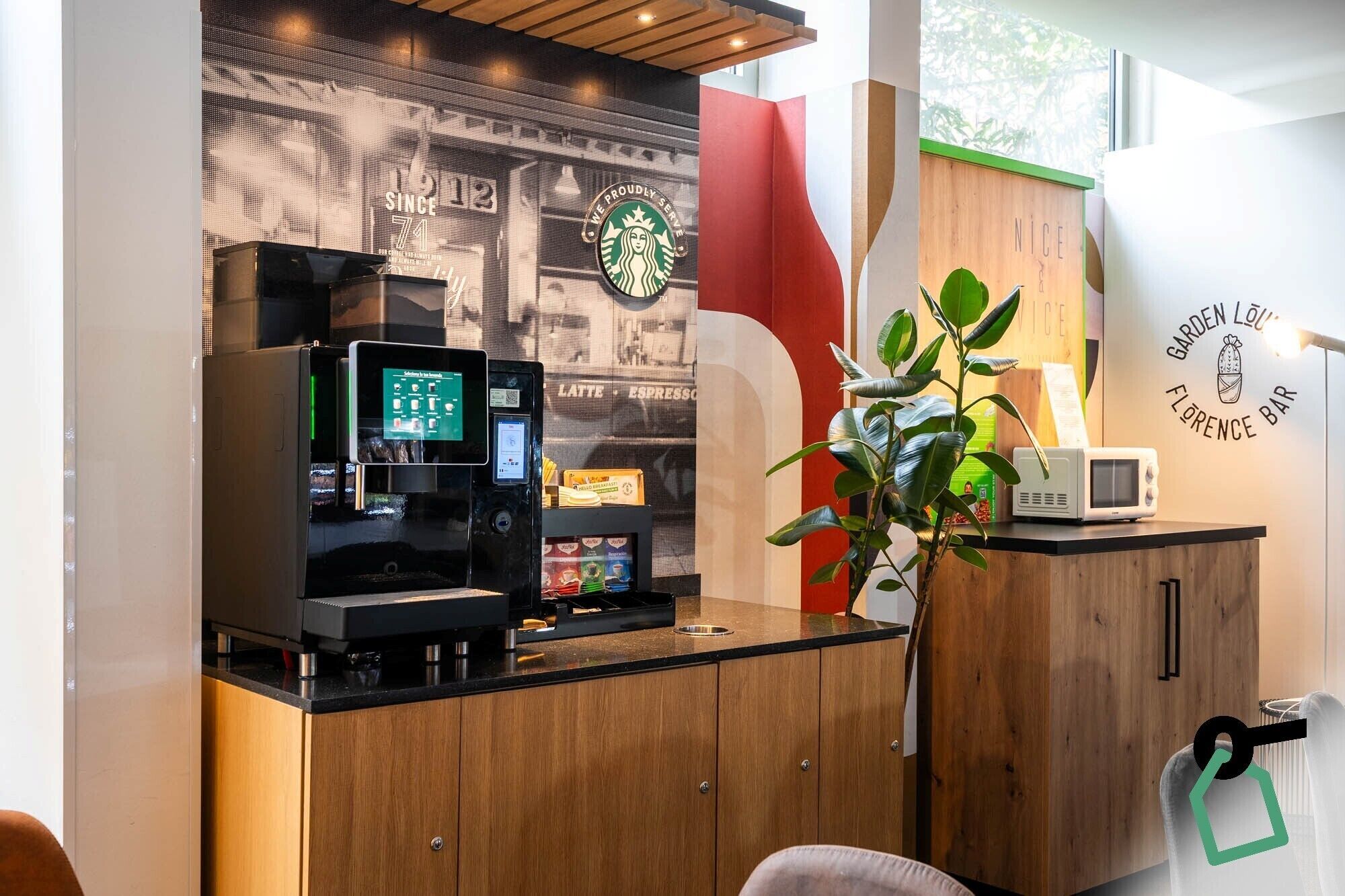 A modern coffee shop interior with a coffee machine, a menu display, and a microwave on the counter.