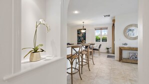 Een moderne keuken met een centraal eiland, barkrukken en een potorkidee.