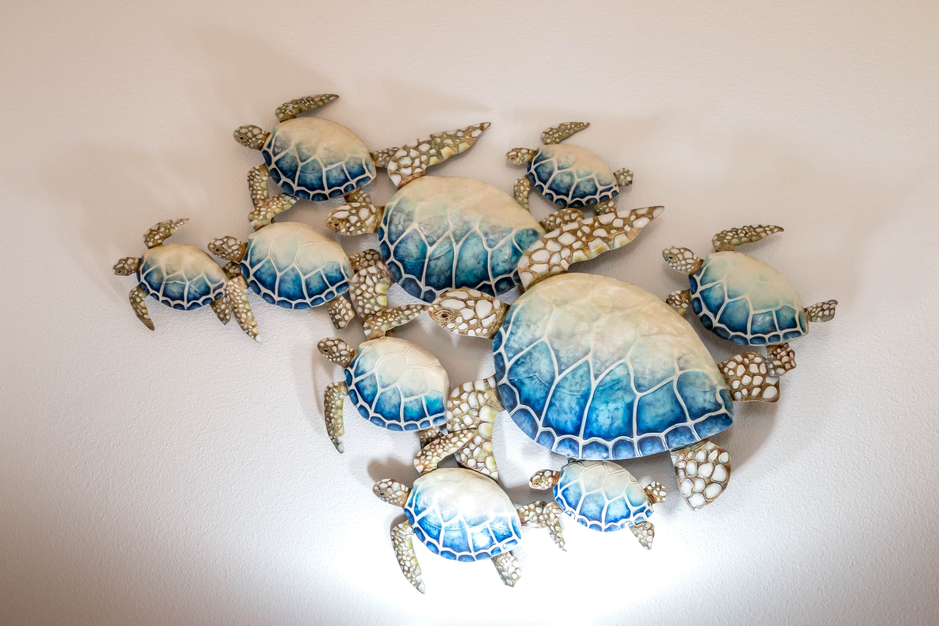 En samling dekorative skildpaddefigurer mod en enkel væg.