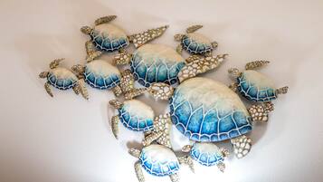 En samling dekorative skildpaddefigurer mod en enkel væg.