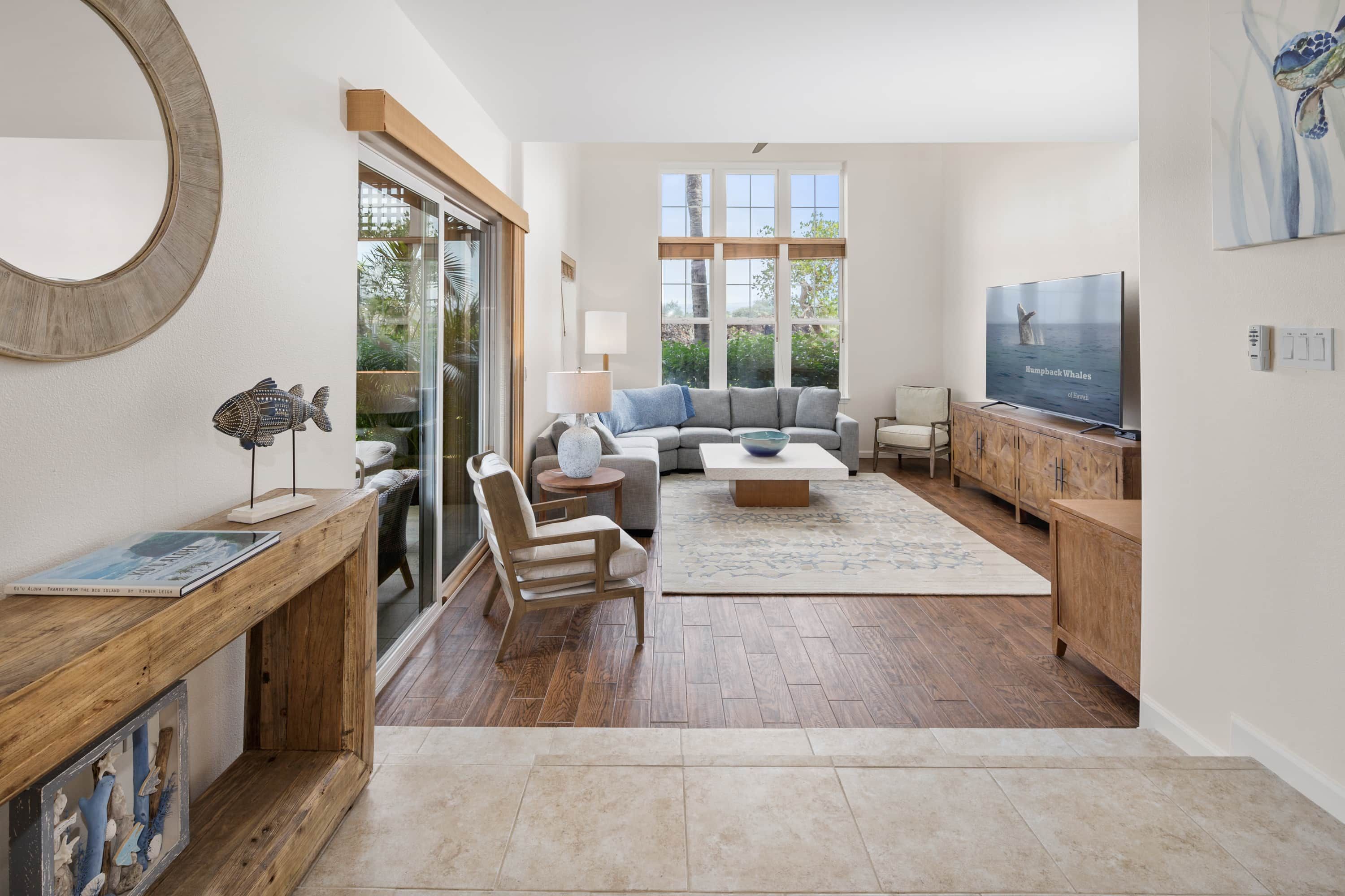 A spacious living room with a large window, a television, and a wooden coffee table.