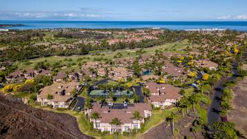 A residential area with houses, a golf course, and a large building with a swimming pool.