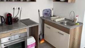 A modern kitchen with stainless steel appliances, wooden cabinets, and a built-in oven. - Modern family home near Debrecen Airport &City Center, with own bathroom&kitchen (Debrecen)