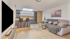 A modern living room with a sofa, a coffee table, and a TV. - House with Private Terrace Near the Sea and Wi-Fi in Gran Canaria (Telde)