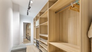 A walk-in closet with open shelving, a hanging rod, and a small cabinet. - House with Private Terrace Near the Sea and Wi-Fi in Gran Canaria (Telde)
