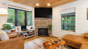 Un salon chaleureux avec une cheminée en pierre, des canapés en cuir et une table basse en bois.