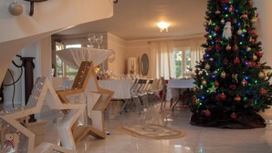 A dining area with a Christmas tree, star-shaped decorations, and a chandelier. - villa Kokalis resort 4 with private pool with a fantastic view (Γουβες)