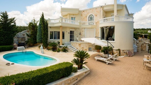 A large, two-story house with a swimming pool, outdoor seating, and a stone facade. - villa Kokalis resort 4 with private pool with a fantastic view (Γουβες)