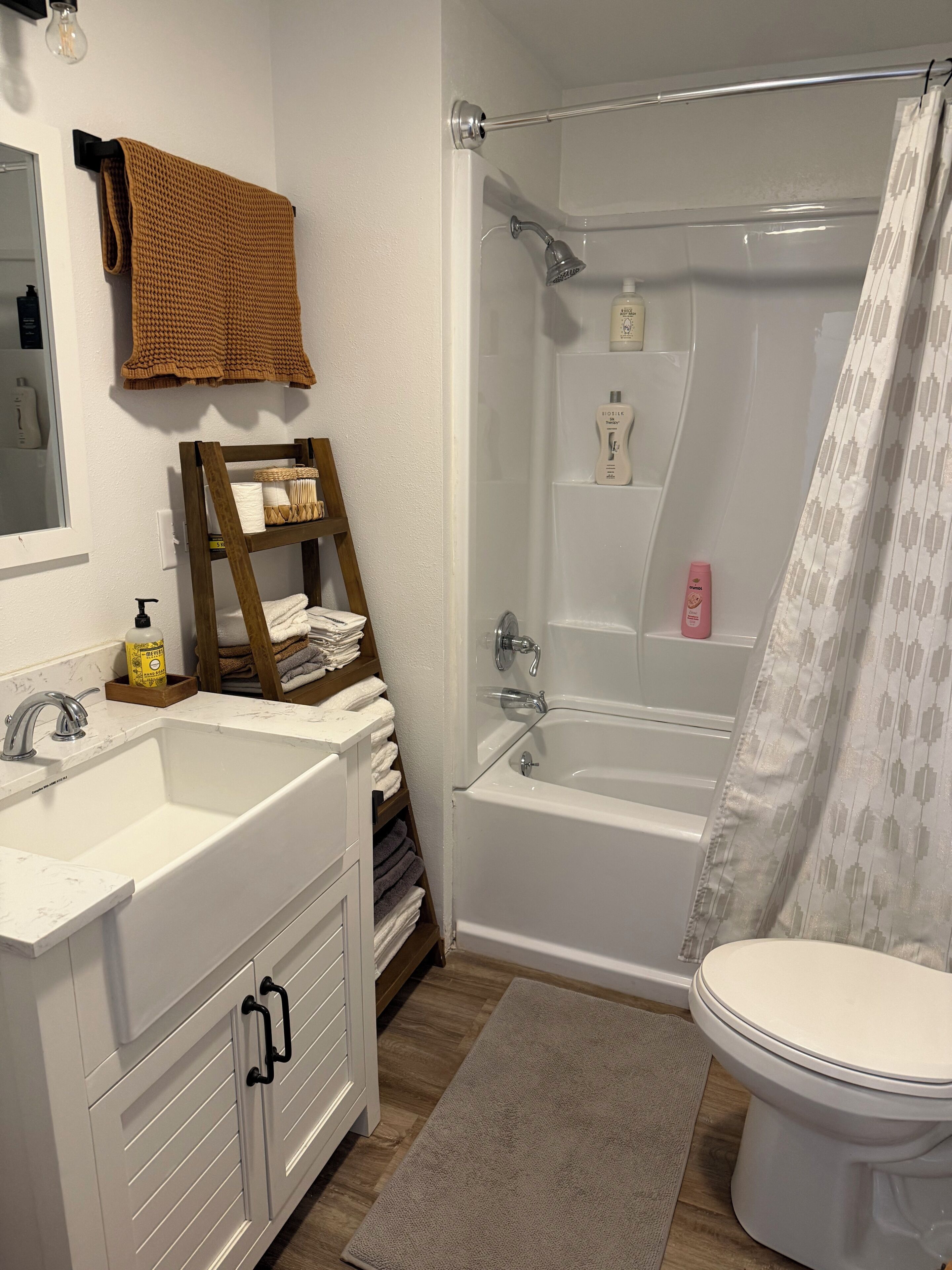 Un baño con un lavamanos blanco, una bañera, un inodoro y una cortina de ducha.