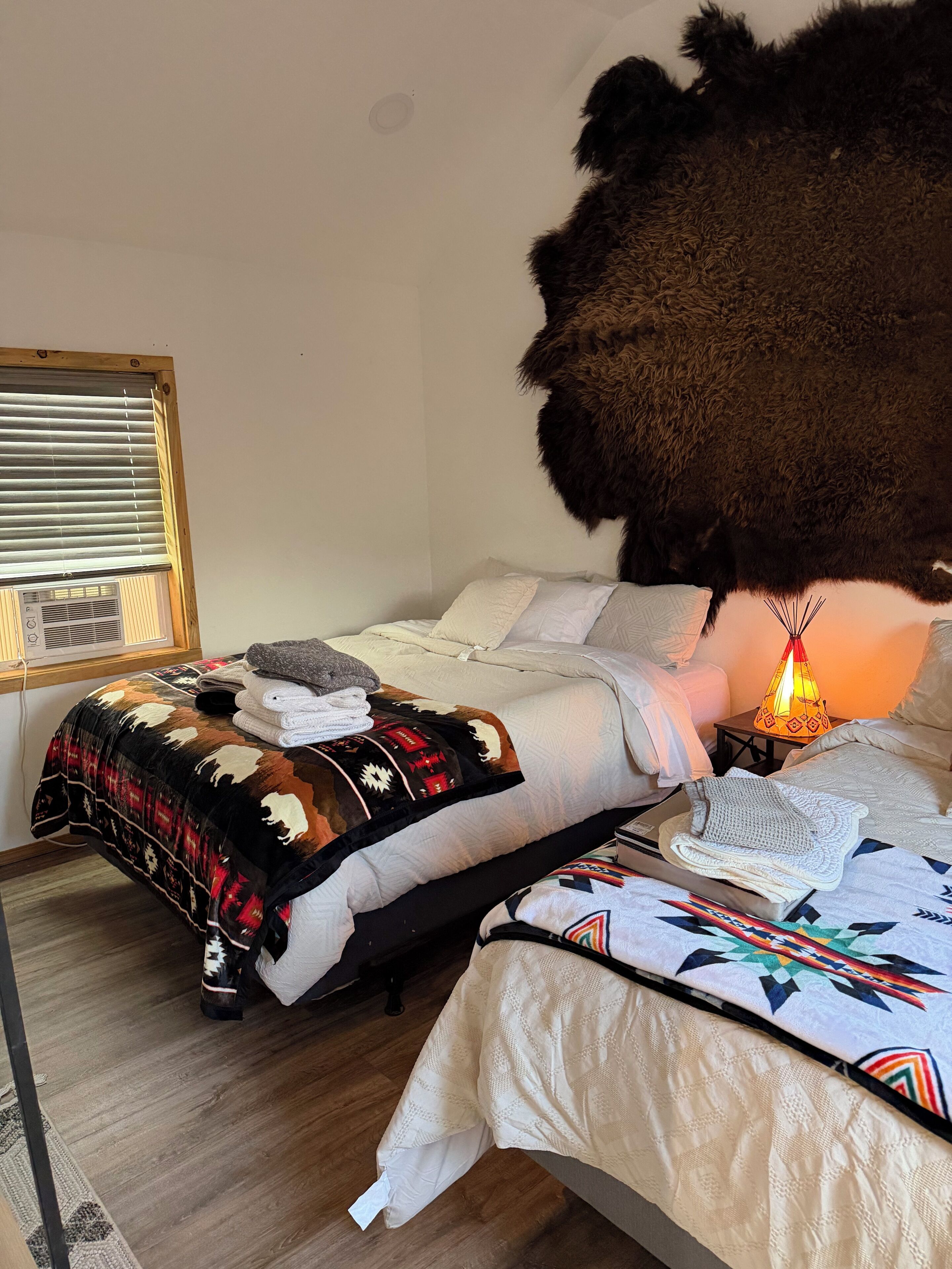 Un dormitorio con cama, un calefactor, una ventana con persianas y una alfombra.
