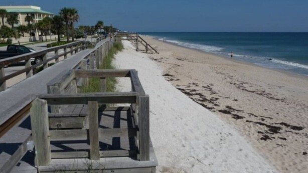 A beach with a wooden boardwalk leading to the shore. - NEW 3-bedroom house with AC in Vero Beach—13 min to beach! (Vero Beach)