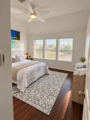 A bedroom with a bed, a ceiling fan, a window with blinds, a rug, and a door with towels. - Luxury Lake Front +Private Dock +Kayak +Fishing +4BR, 3.5Bath +Sleeps 12 (Cypress)