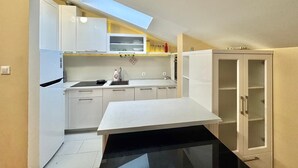 A compact kitchen with white cabinets, a countertop, and a skylight. - Rooftop Elegance Suite (Budva)