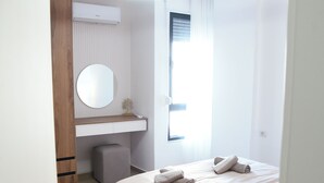 Um quarto moderno com cama, mesa de cabeceira e luminária suspensa.