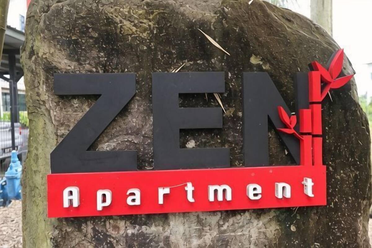 Une enseigne pour «ZEN Apartment» avec une grande police de caractères en gras et un ruban rouge en guise de décoration.