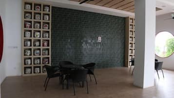 A room with a tiled wall, a ceiling fan, a bookshelf, and a round window.