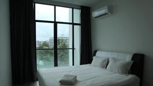 A hotel room with a large window, a bed with white linens, and an air conditioning unit on the wall. - Zen66 @ Roxy Serviced Apartment (Kuching)