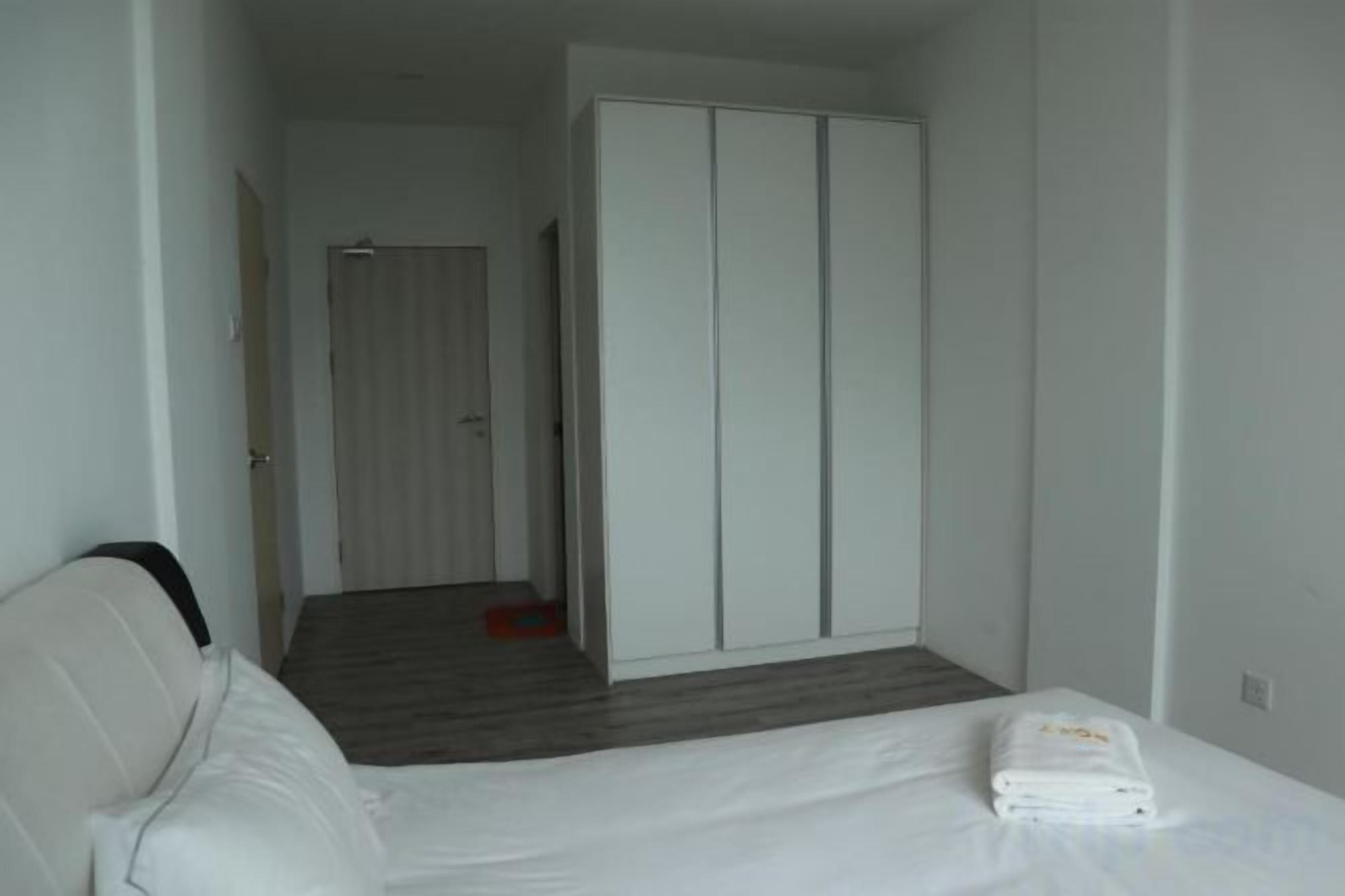 Une chambre d’hôtel comprenant un lit, une armoire et une porte donnant sur une autre pièce.