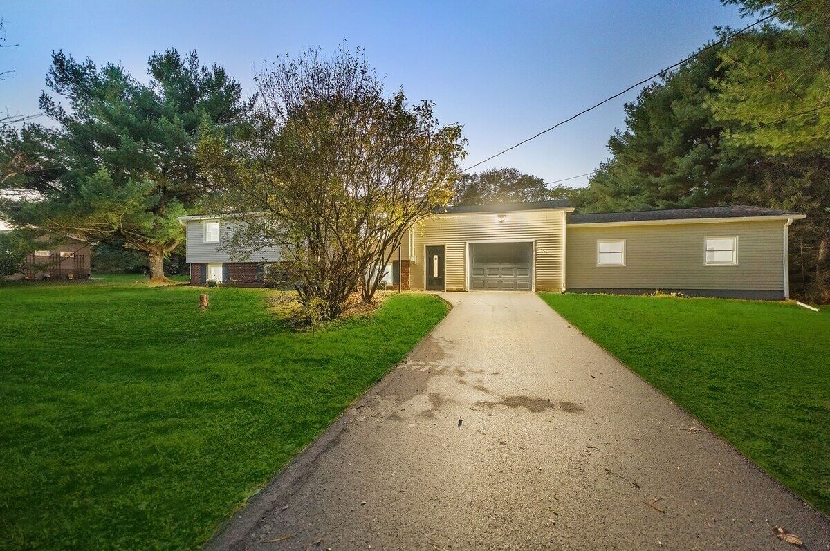 A two-story house with a garage, a front yard, and a driveway.