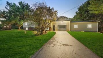 A two-story house with a garage, a front yard, and a driveway.