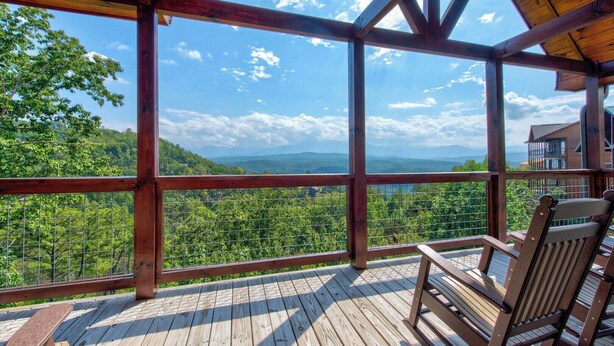 A wooden deck with a view of a mountainous landscape. - Majestic View (Sevierville)