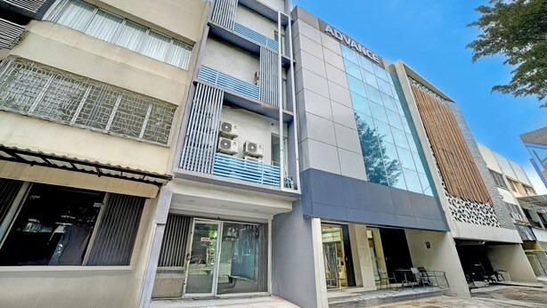 A multi-story building with a modern facade, including a prominent 'ADVANCE' sign on the upper level. - Capital O 94914 Kemayoran Guest House (Jakarta)