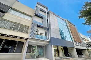 Un immeuble à plusieurs étages doté d’une façade moderne, avec une grande enseigne « ADVANCE » bien visible sur le niveau supérieur.