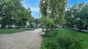 A paved pathway in a park with trees and greenery on both sides. - Capital O 94914 Kemayoran Guest House (Jakarta)