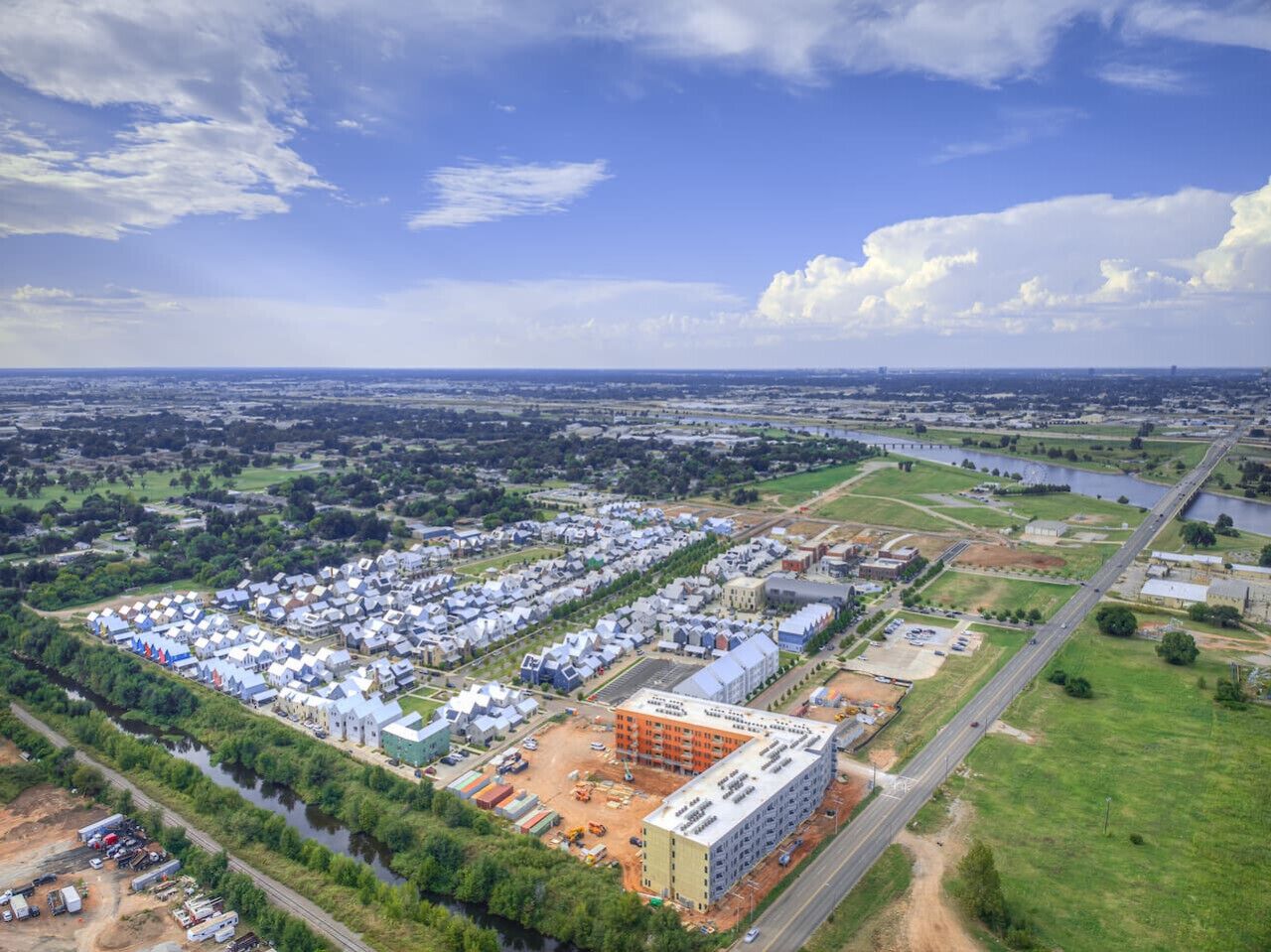 Zona industriale con diversi edifici, un'ampia area aperta e un fiume.