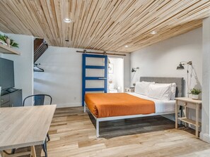 A bedroom with a bed, bedside table, and a desk. - Modern Loft Apartment - Sleeps 4 (Oklahoma City)