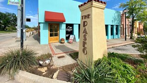 A building with a blue facade, a red awning, and a sign that reads "THE DASEO". - Updated Garage Apartment (Oklahoma City)
