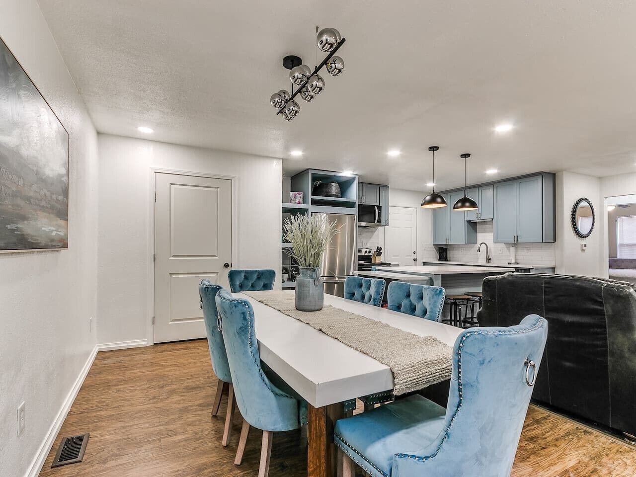 A modern kitchen with a central island, built-in appliances, and pendant lighting.