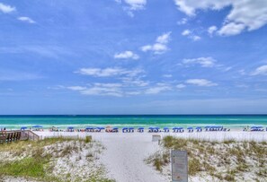 A beach path leading to a sandy beach with blue umbrellas and beach chairs. - Sheer Bliss (Miramar Beach)