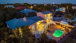 Une maison à deux étages avec une piscine, un patio couvert et une cour clôturée.