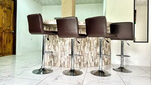 A bar area with four stools and a marble-tiled floor. - Blu House Luxe: 6BR for Large Families, Jacuzzi and Panoramic Views (Provincia de Alajuela)